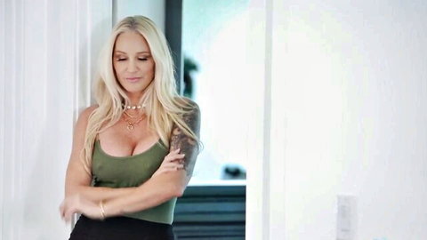 Blonde bombshell Alexis Malone in revealing green top, arms crossed tease