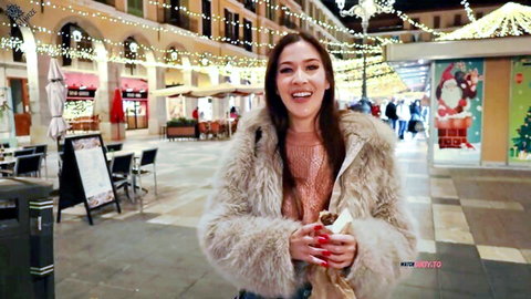 MaryHaze smiles in sexy fur coat under Christmas lights in festive outdoor POV