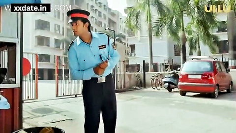 Policeman in blue uniform standing by red car on street with palm trees