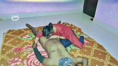 Sexy Indian woman in red dress nuzzling shirtless man's bare chest on bed
