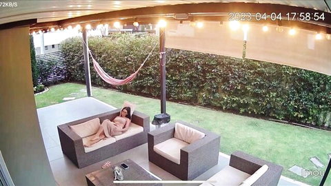 Nude babe lounging naked on outdoor patio couch exposing tits and pussy