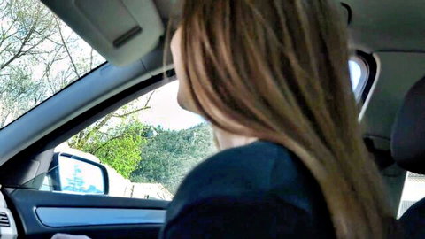 Brunette woman with long hair looking out car window on scenic drive