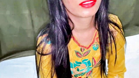 Seductive Indian woman with red lips and long purple hair in tight yellow embroidered top teasing