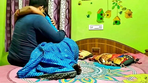 Indian couple passionately hugging from behind on colorful bed