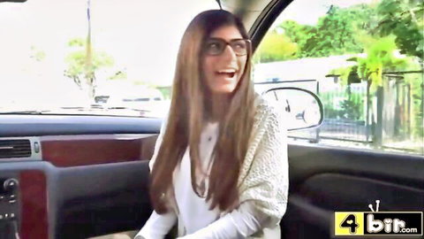 Mia Khalifa in glasses smiling in car before BBC stretching scene