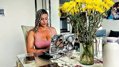 Busty brunette MILF in tight pink tank top showing huge cleavage while typing on laptop