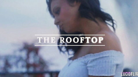 Brunette babe in off-shoulder white top posing seductively on rooftop