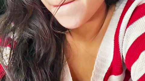 Sexy brunette babe smiling with parted lips teasing in red striped sweater