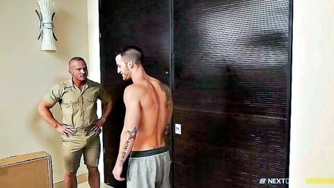 Muscular tattooed white hunk shirtless in low sweatpants eyed by uniformed athletic stud