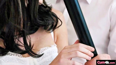 Asian woman in white lace bra with black hair, man in shirt holding toy, swinger tease