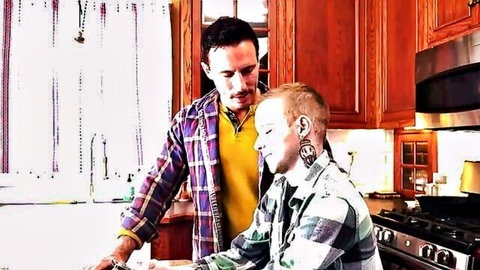Intimate dad-son moment in kitchen with mature man over young redhead
