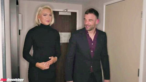 Blonde bombshell in tight black turtleneck dress flaunting athletic body and natural tits with suited hunk