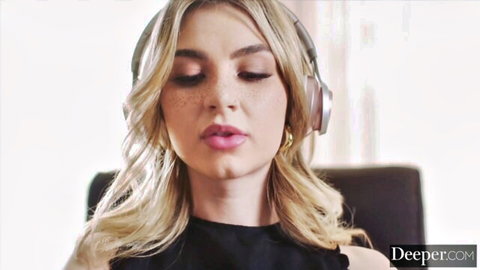 Blonde beauty with headphones smirking seductively in black top closeup