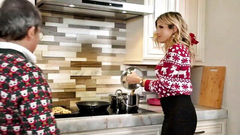 Blonde in sexy reindeer Christmas sweater pouring pan in kitchen with older man watching
