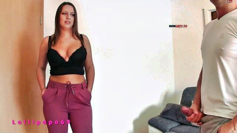 Brunette MILF with big tits in black lace bra and pink pants teases man holding his hard cock