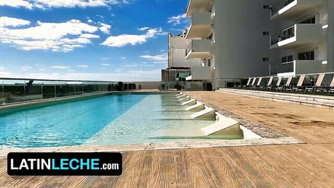 Sunny infinity pool at luxury hotel overlooking ocean, Latin Leche style