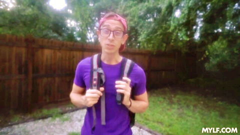 Man with pink headband, glasses, purple shirt and backpack standing in backyard on MYLF.com
