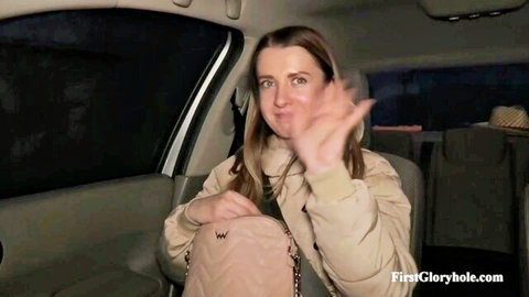 Smiling brunette in puffer jacket waves excitedly in car before first gloryhole adventure