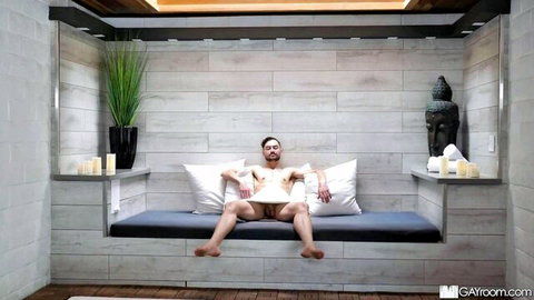 Naked young muscular man lounges legs spread exposing big uncut cock balls in sauna