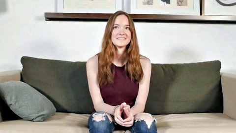 Hazel Moore handcuffed and smiling in tank top and ripped jeans