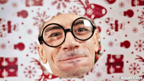 Mischievous man with nerdy glasses smirks naughtily in festive Christmas background