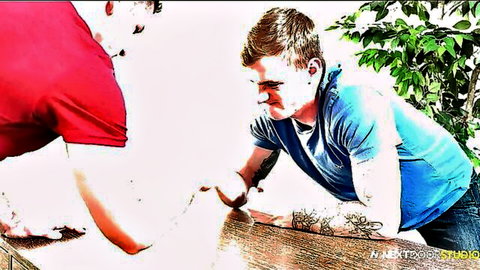 Two young tattooed gay men passionately gripping wrists over wooden table
