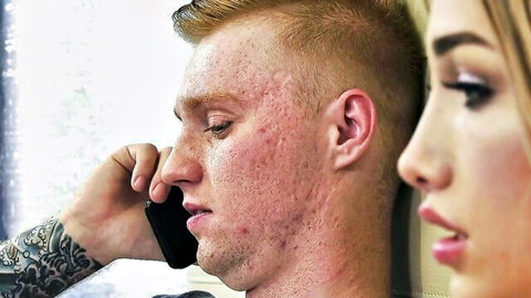 Tattooed ginger guy with buzzcut on phone call beside sexy long-haired blonde woman close-up