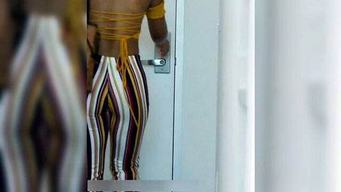 Topless ebony babe in striped pants grabs door handle showing bare back and ass crack