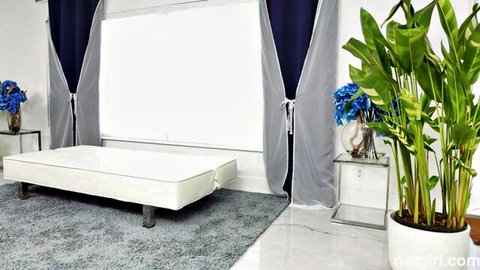 Katie's luxurious bedroom setup with white bed and blue floral decor