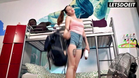 Elena Vega in pink crop top and denim shorts posing in hostel