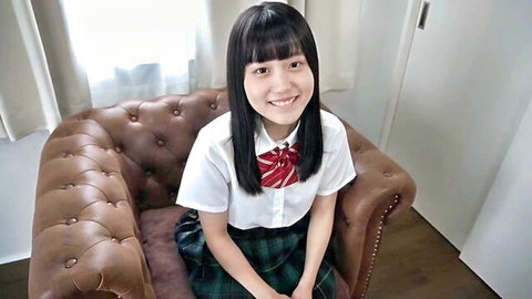 Cute Japanese schoolgirl babe smiling in tight uniform skirt on leather chair