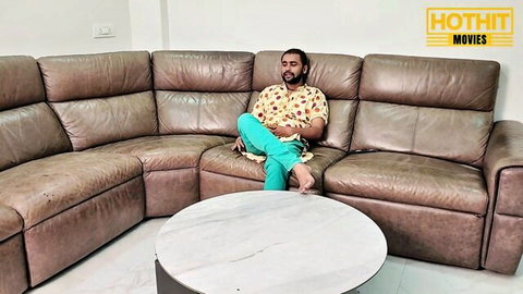 Relaxed bearded stepson lounges on couch in stepmom seduction tease