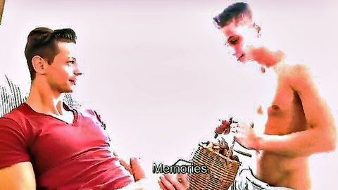 Muscular shirtless gay hunk holds basket of roses teasing seated stud in red V-neck shirt