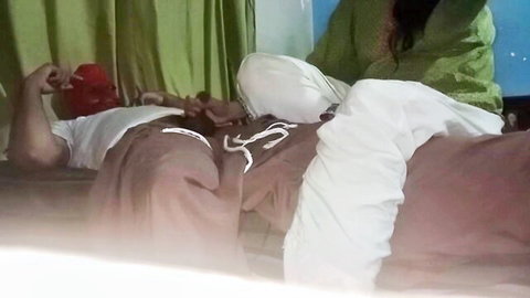 South Asian woman in green salwar rides man's exposed cock on bed with pants pulled down