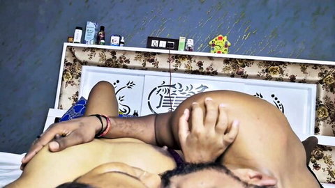 South Asian couple fucking missionary style with man gripping woman's thigh on ornate bed
