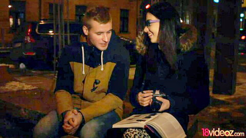 European teen in glasses chats intimately with guy outdoors at night