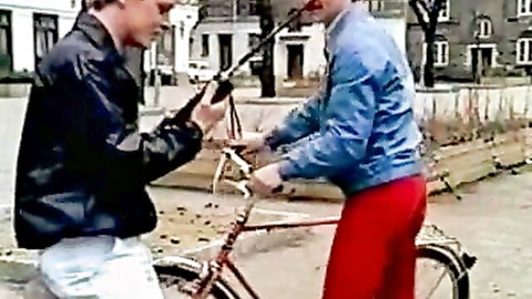 Vintage street scene with two men in jackets confronting near bike, Color Climax style