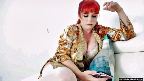 Penny Pax in open kimono robe showing deep cleavage, seductive pose on couch