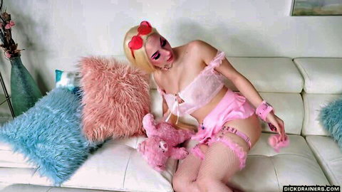 Busty blonde Skylar Vox in pink lingerie, stockings, and cuffs posing seductively with teddy bear