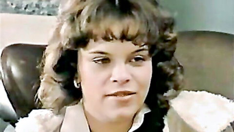 Vintage brunette with curly hair in ruffled blouse from Color Climax lesbian scene