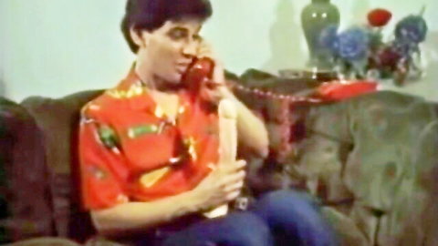 Retro man in Hawaiian shirt talks on phone gripping flesh dildo handjob style