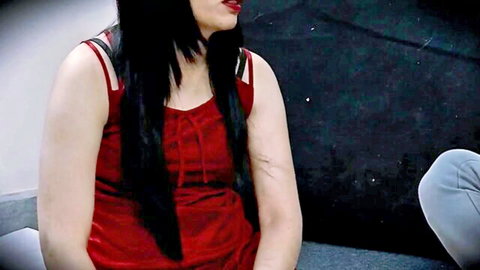 Sexy Indian woman with long black hair in red tank top sitting teasingly beside man