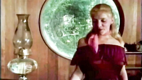 Vintage blonde in sheer maroon off-shoulder dress seductively touches lips in erotic tease
