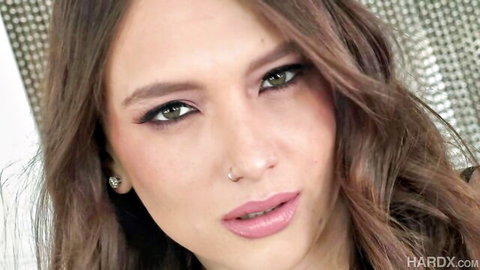 Izzy Lush seductive close-up with wavy brunette hair and glossy lips