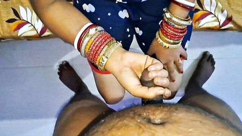 Indian housewife with red bangles grips thick dark cock with both hands on bed