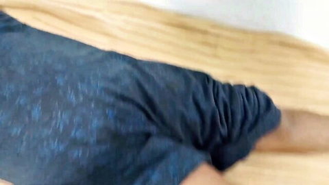 Indian woman in dark pants lying on bed, legs spread in suggestive pose