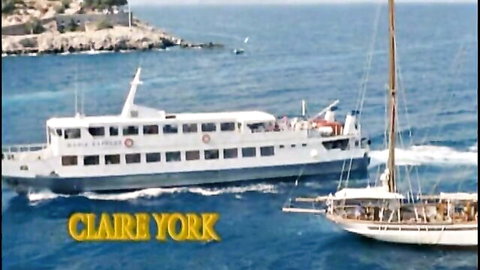 White ferry boat named Claire York sailing near rocky coast with sailboat in sea