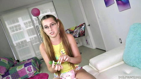 Melody Parker blonde in pigtails, glasses, yellow top and diaper holding green toy