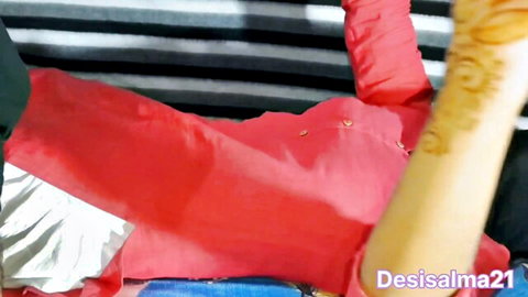 Desi girl in revealing red outfit lying back with henna hands, Indian village vibe