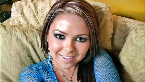 Smiling brunette MILF in sheer blue fishnet top exposing huge cleavage and tits